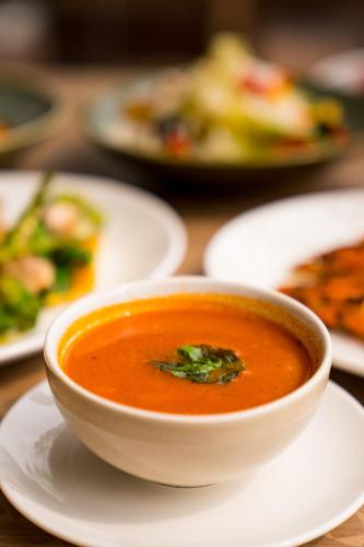 a bowl of tomato soup on a white plate at Holitel Anjuna in Arpora