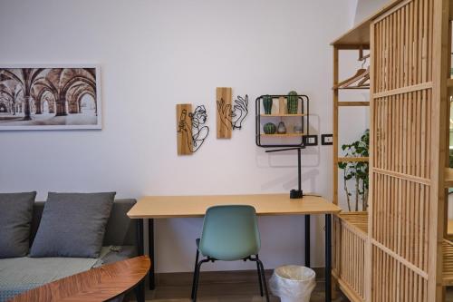 a desk and a chair in a room with a couch at Homely Catania in Catania