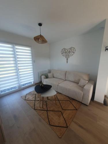 un salon avec un canapé et une table dans l'établissement Abeille, à Aydoilles