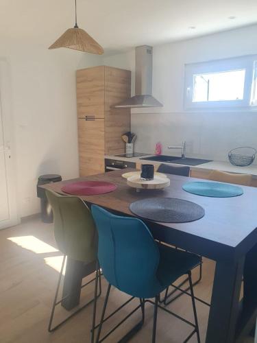 une cuisine avec une table et des chaises dans une cuisine dans l'établissement Abeille, à Aydoilles