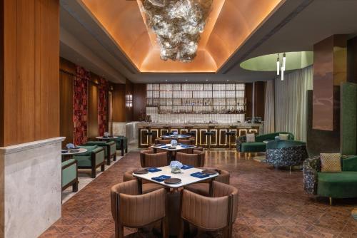 a restaurant with tables and chairs and a bar at Taj Mussoorie Foothills, Dehradun in Dehradun