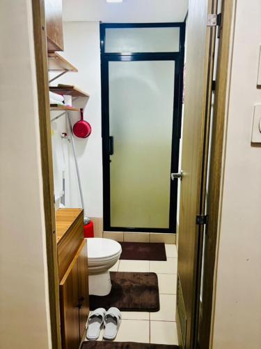a bathroom with a toilet and a door with a mirror at Balauro's Haven in Trece Martires