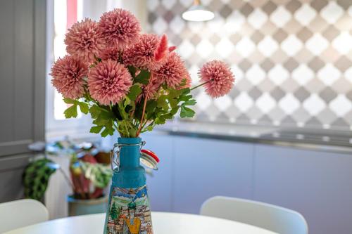 a vase filled with pink flowers sitting on a table at LaMalatestina Suite - Apartment in front of the Castle in Rimini