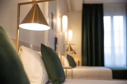 a living room with a couch and a lamp at Grand Hôtel Saint-Aignan in Saint-Aignan