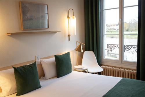a hotel room with a bed and a window at Grand Hôtel Saint-Aignan in Saint-Aignan