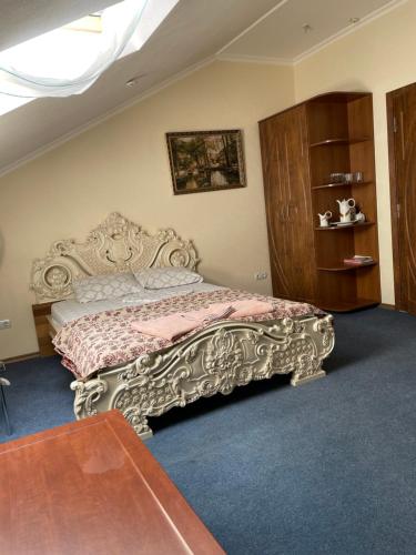 a bedroom with a bed with an ornate headboard at Sava Dream in Zhytomyr