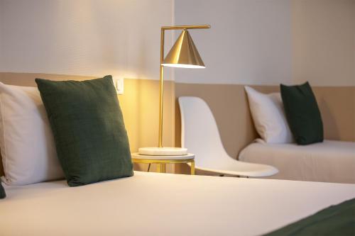 a bedroom with a bed with a lamp and a couch at Grand Hôtel Saint-Aignan in Saint-Aignan