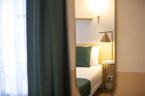 a mirror reflection of a bed in a bedroom at Grand Hôtel Saint-Aignan in Saint-Aignan