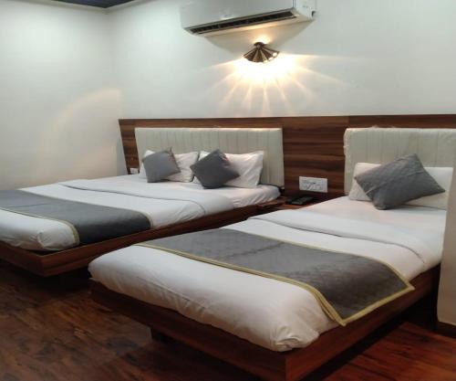 two beds sitting next to each other in a room at HOTEL AIR VIEW Near Airport in Mumbai