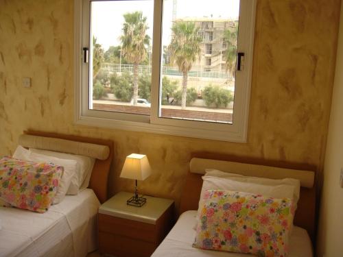 um quarto com 2 camas e uma janela em Athena Villa em Agia Napa