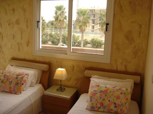 a bedroom with two beds and a window at Athena Villa in Ayia Napa