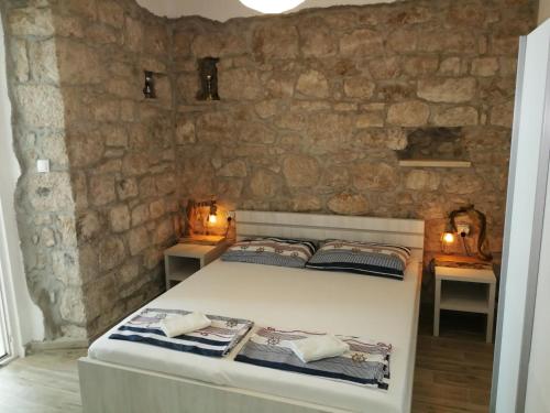 a bedroom with a bed in a stone wall at Apartments Luna in Žuljana