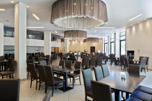 a dining room with tables and chairs and a chandelier at Long Beach Hotel & Resort in Lóngos