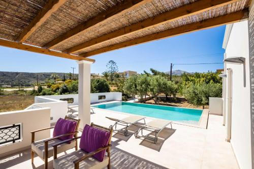 a villa with a swimming pool and a patio at Zetes Luxury Suite in Karpathos Town