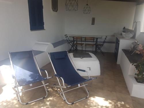 a room with two chairs and a table and a table and a kitchen at Iddu & Idda in Stromboli