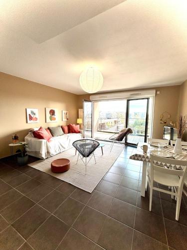 un salon avec un lit et une table dans l'établissement L'Alta - Appartement spacieux et lumineux 2 chambres proche Tram, Universités, Bordeaux Centre, à Talence
