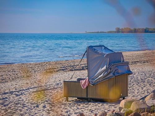 a boat sitting on a beach next to the water at Strand Lounge Kronsgaard in Kronsgaard