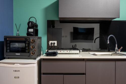 a kitchen with a microwave and a stove at Ehad Ha'am Urban 3BR עם מקלט in Haifa