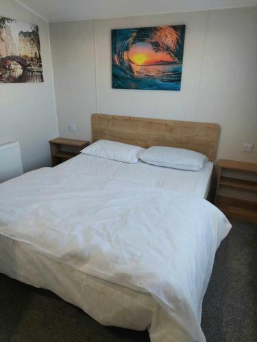 a bedroom with a large white bed with two pillows at 6 berth golden sands Rhyl in Kinmel Bay