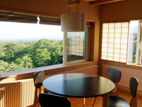 a dining room with a table and chairs and windows at Wakaki Ryokan - Nasu Yumoto Onsen in Nasu