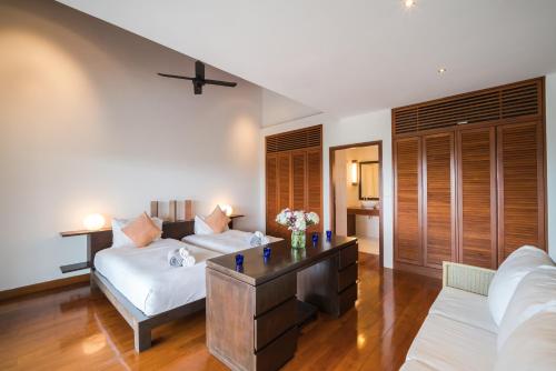 a living room with a couch and a table at Vichuda Hills by RESAVA in Layan Beach