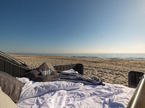 a bed on the beach with a teddy bear on it at Strand Lounge Kronsgaard in Kronsgaard