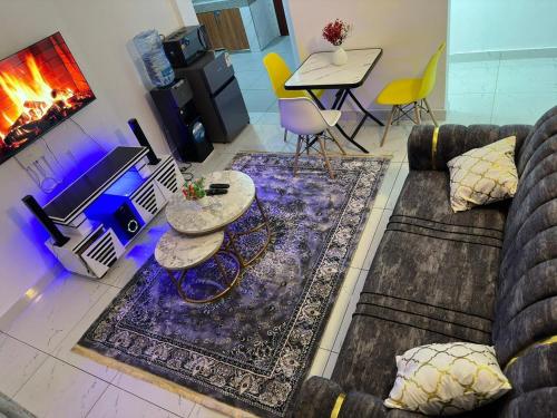 sala de estar con sofá, mesas y chimenea en Cassy Apartments, en Mombasa