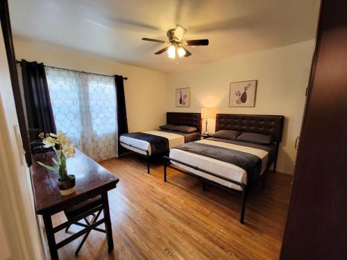 a living room with two beds and a ceiling fan at Perfectly located Pico Robertson ground floor 3 bedroom apartment Walk to restaurants WIFI TV Game Console Parking 5 minutes to Rodeo Drive in Los Angeles
