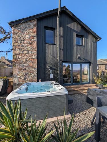 a house with a hot tub in a yard at Old Brewery Barn, Ullswater, Lake District in Penrith