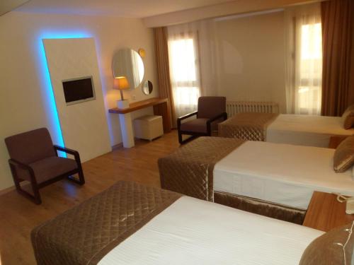 a hotel room with two beds and a mirror at Hotel Baylan İzmir in Izmir