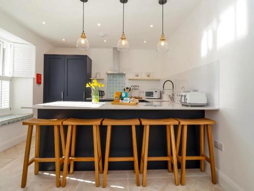 a kitchen with wooden stools at a kitchen counter at The Haven in Marazion