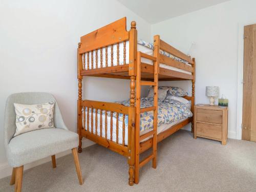 a bedroom with a bunk bed and a chair at The Haven in Marazion