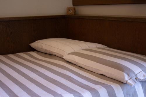 a bed with two pillows on top of it at Locanda La Ruscoletta in Telve
