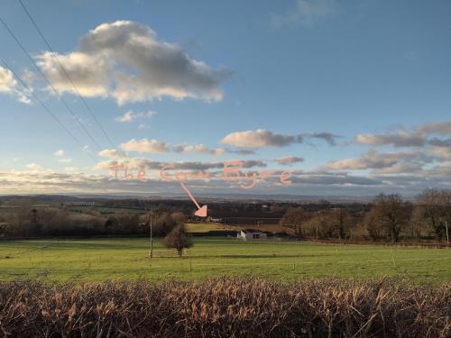 a field with a sign that says the cureiction at The Cow Byre in Dursley