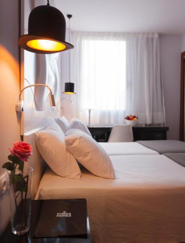 a hotel room with two beds and a window at Evenia Rocafort in Barcelona