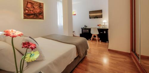 a bedroom with a bed with a vase with flowers on it at Evenia Rocafort in Barcelona