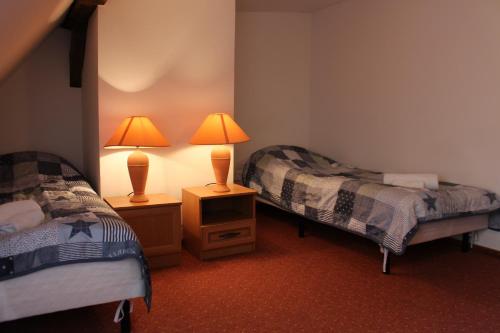 a room with two beds and a lamp on a night stand at Apartament Stara Kamienica in Kętrzyn