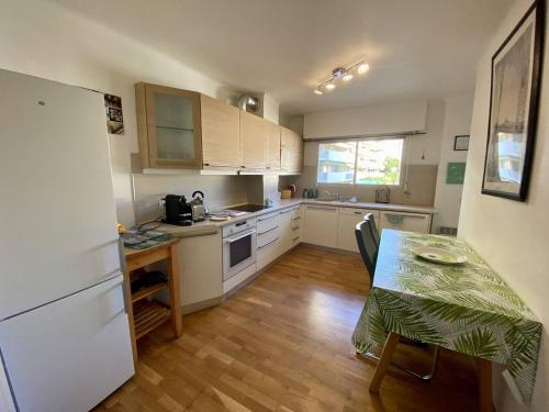 une petite cuisine avec une table, une table et un réfrigérateur dans l'établissement Cannes proche Croisette - 2P tout confort terrasse, à Cannes
