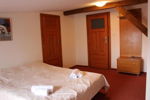 a bedroom with a bed with two towels on it at Apartament Stara Kamienica in Kętrzyn