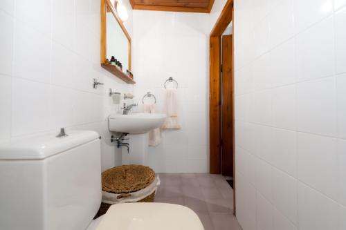 ein weißes Bad mit einem WC und einem Waschbecken in der Unterkunft Villa Ouranos in Kissamos