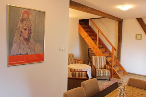 a living room with a painting of a woman on the wall at Apartament Stara Kamienica in Kętrzyn