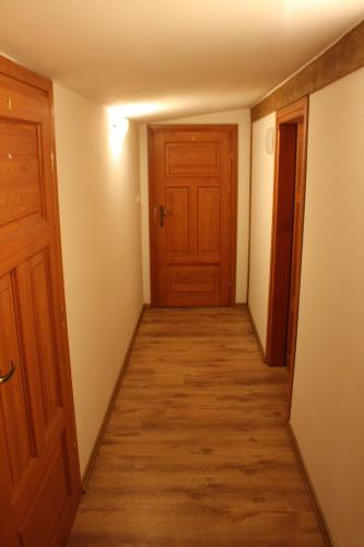 an empty hallway with a door and wooden floors at Apartament Stara Kamienica in Kętrzyn