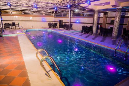 una piscina con luci viola in un edificio di City Base Hotel, Port Harcourt a Port Harcourt