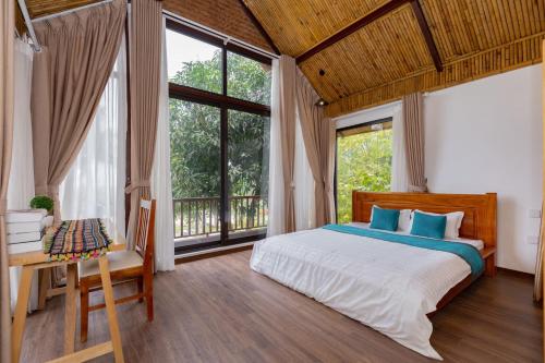 a bedroom with a bed and a large window at Thang Mây Village - Ba Vì in Ba Vì