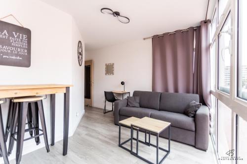 un salon avec un canapé et une table dans l'établissement L'Archipel - Wifi - City centre, à Perpignan