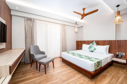 a hotel room with a bed and a chair at Holitel Anjuna in Arpora