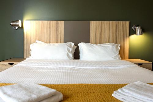 a bedroom with a bed with white sheets and pillows at Hôtel Lodge In Paris 13 in Paris