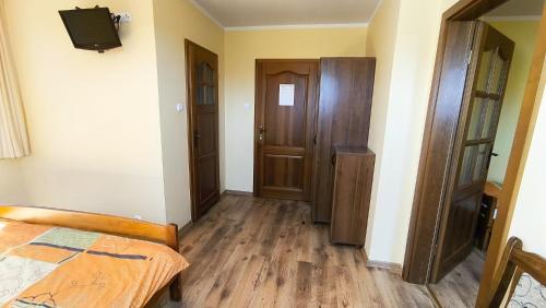 a room with a bed and a tv on a wall at Jaś i Małgosia nad Jeziorem Wigry in Rosochaty Róg