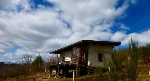 a small house on a hill in a field at Studio de pleine nature idéal pour se ressourcer en solo in Chenaillers-Mascheix