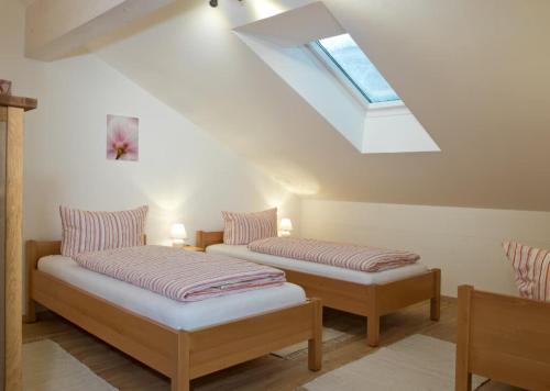 two beds in a room with a skylight at Ferienhof "Schoppa-Haisl" in Sonnen